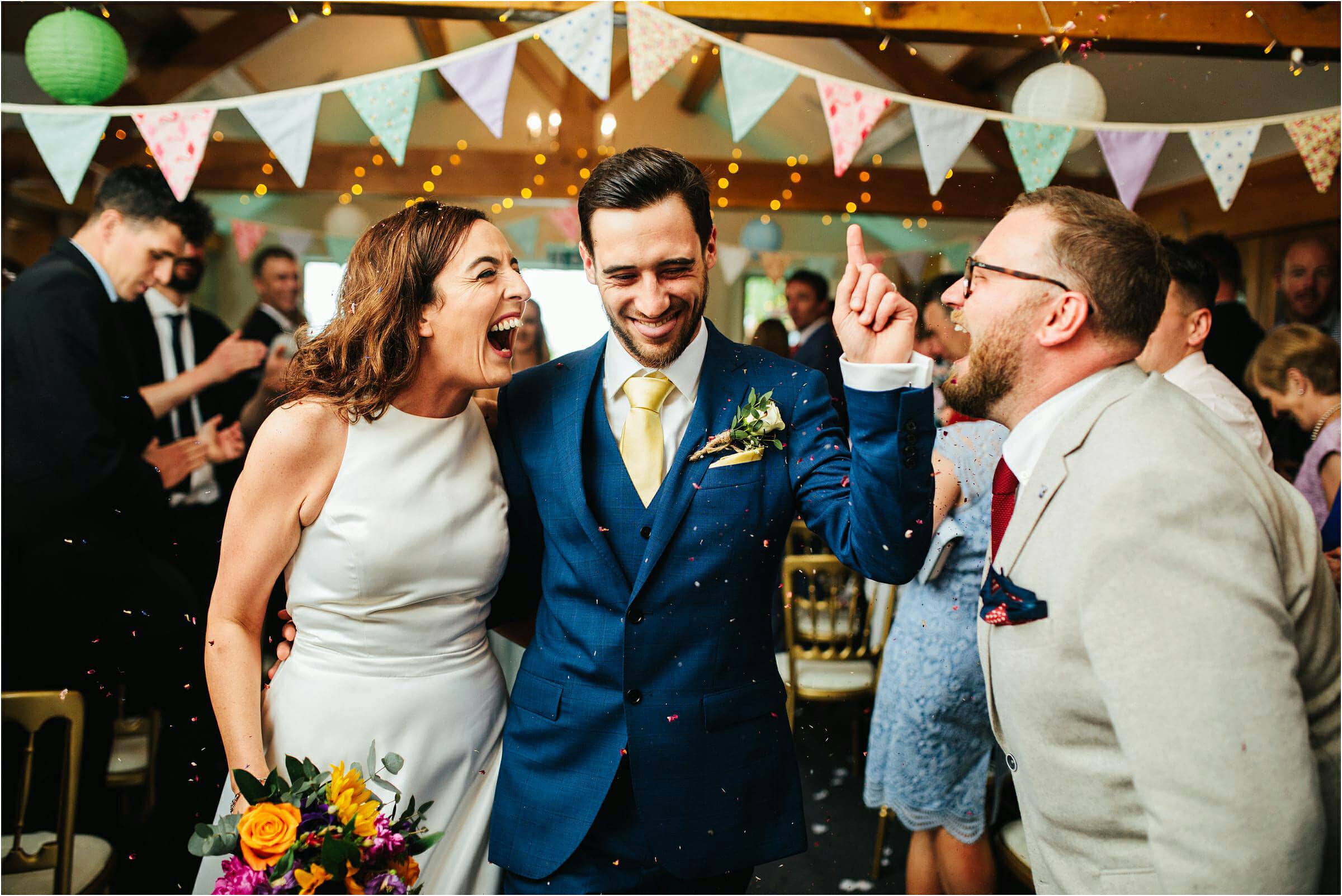 bride and groom celebrating walking down the aisle at Heaton House Farm after getting married