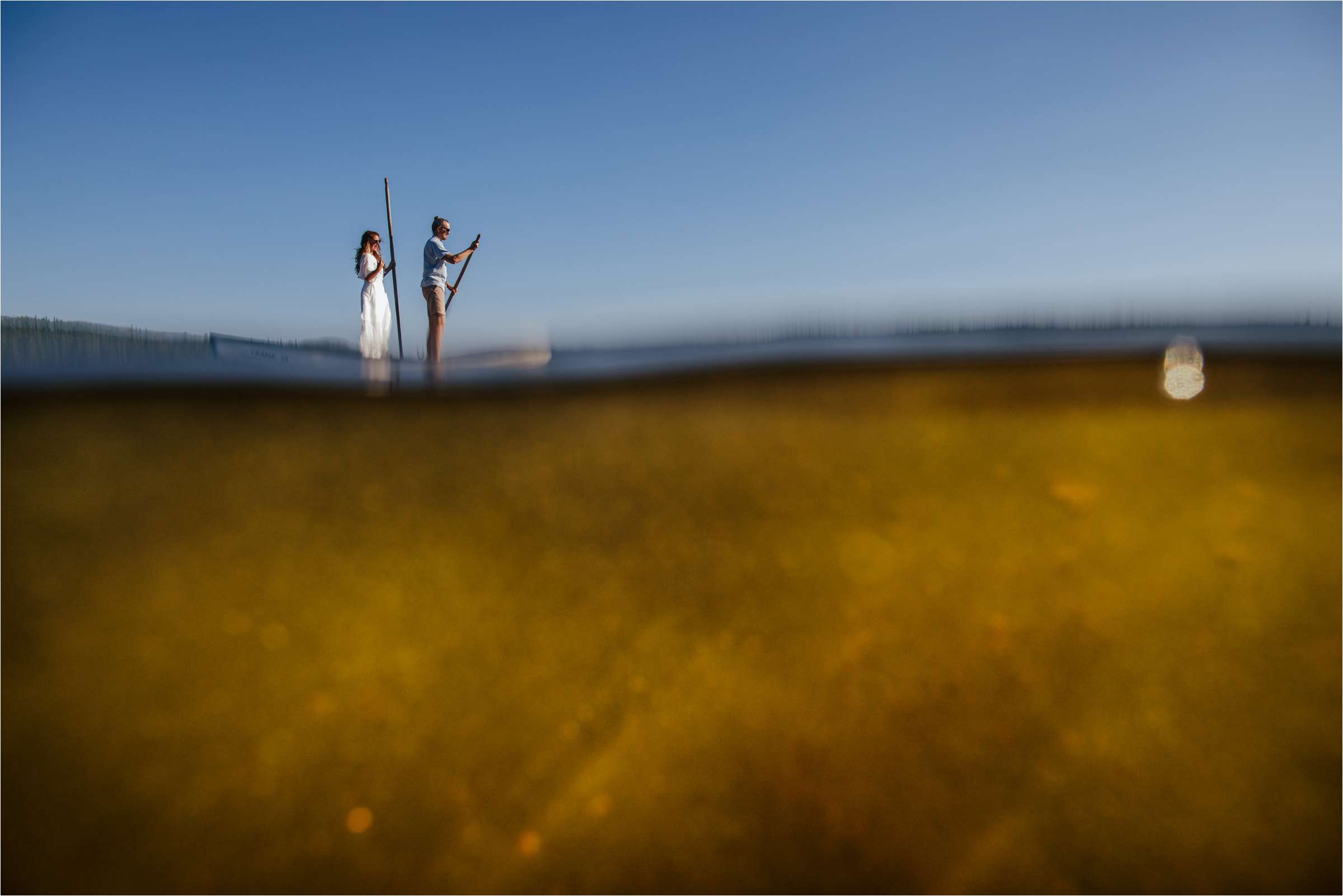 a bride and groom on a paddle board