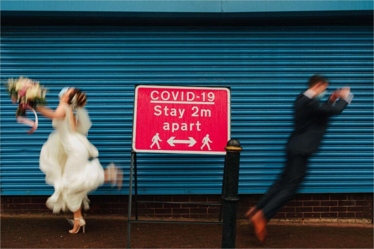 bride and groom jumping away from each other