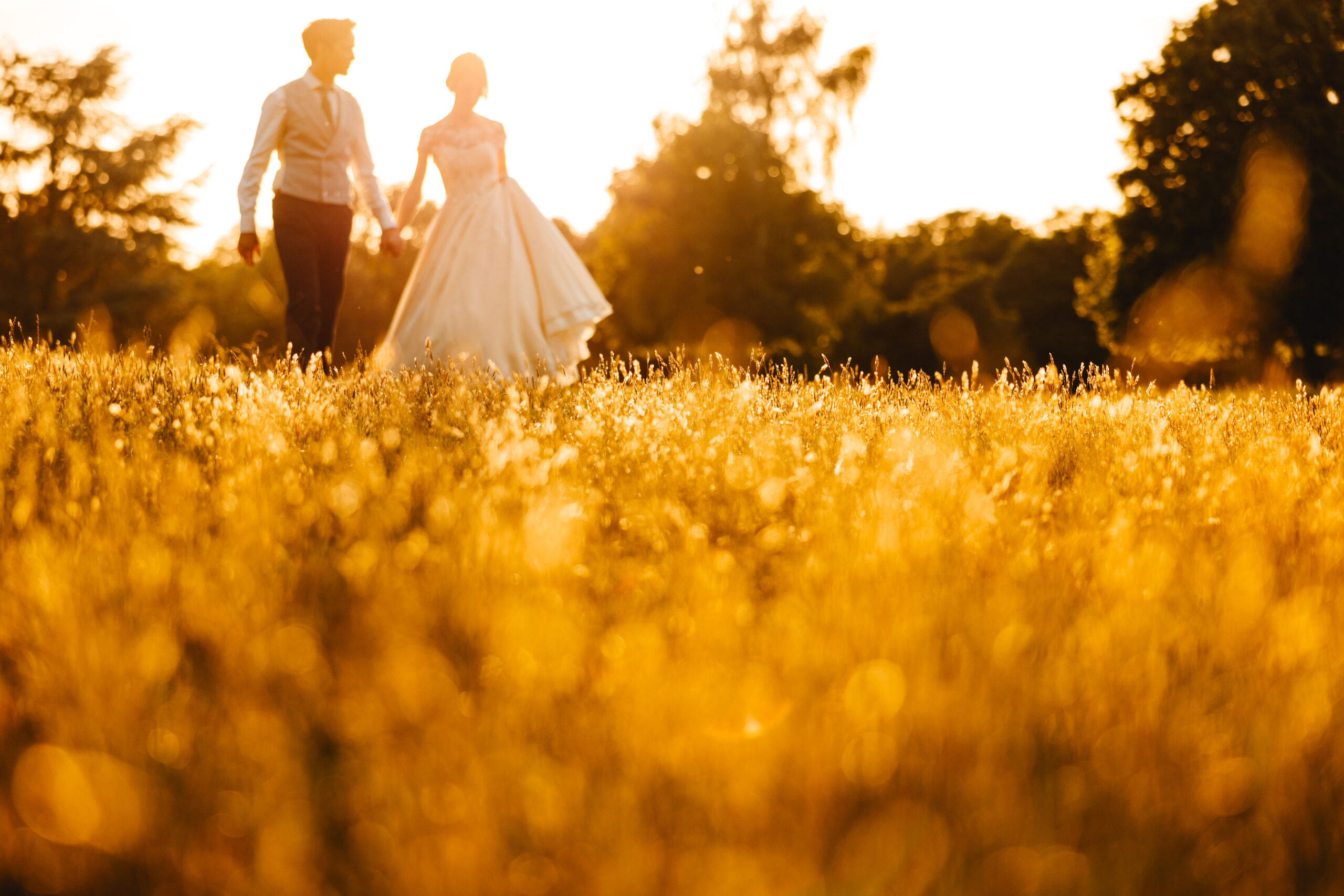 a couple walking through a field in France 